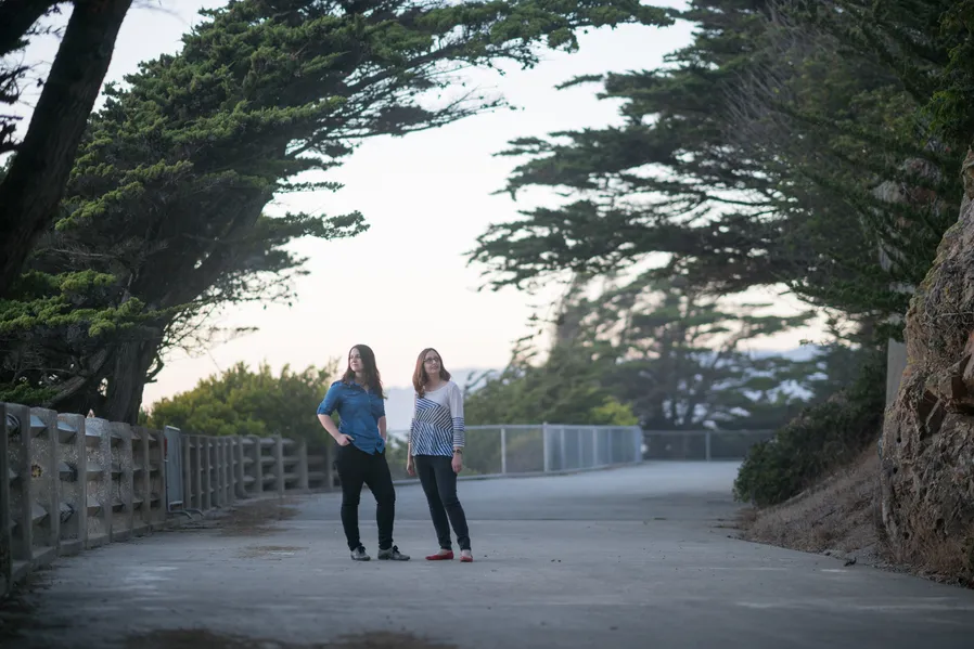 Emma & Julie standing on the path at Land's End looking in different directions from each other