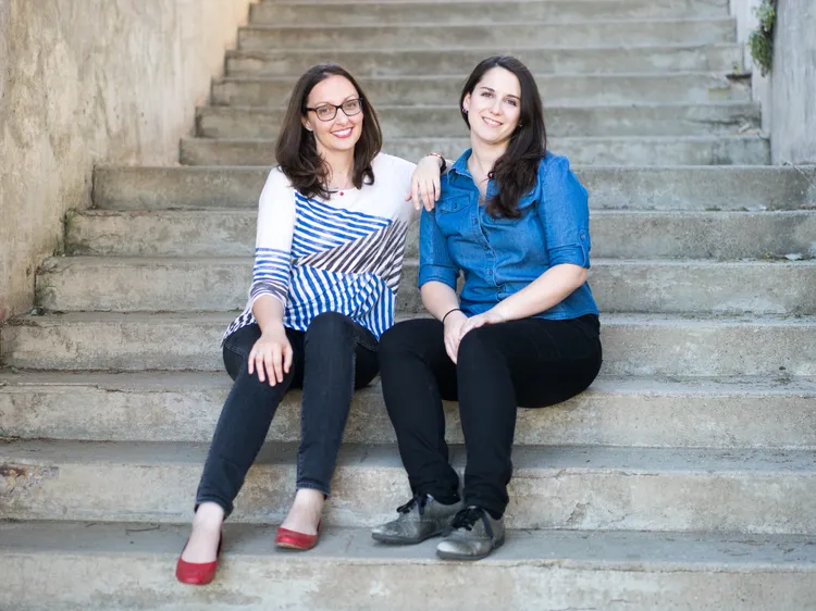 Julie & Emma sitting on the steps, smiling